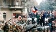 Czechoslovakia -- Youngsters holding a Czechoslovak flag stand atop an overturned truck as other Prague residents surround Soviet tanks in Prague, 21Aug1968