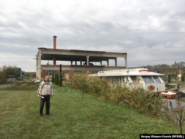 Предприниматель Александр Коваль рядом с недостроенной гостиницей и пришвартованным кораблем. Павловский район