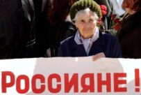 A woman holds a sign saying \