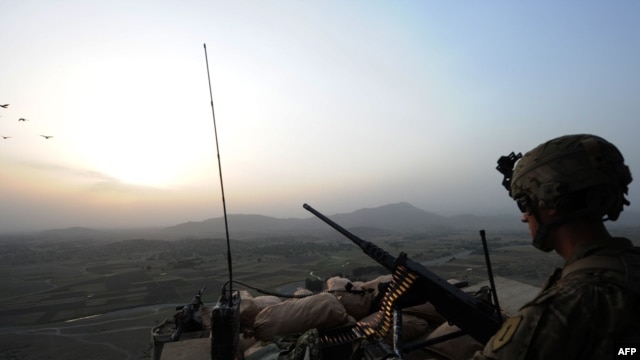 A U.S. soldier stands guard on a watch tower overlooking villages at Combat Outpost Sabari in the Khost Province in June