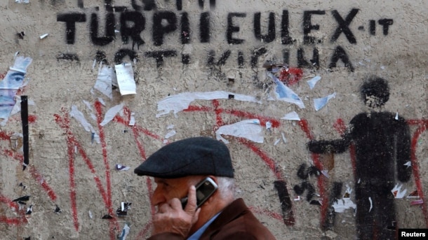 Čovek prolazi ispred grafita "Sramota EULEX-a" u Prištini