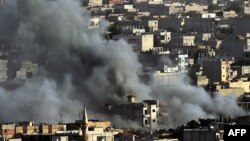 Smoke from an air strike by the U.S.-led coalition rises in the Syrian town of Ain al-Arab, known as Kobani by the Kurds, as seen from the Turkish-Syrian border in the southeastern village of Mursitpinar on October 13.