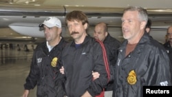 The Russian report says that the case of jailed Russian arms dealer Viktor Bout (center) shows U.S. "double standards" when it comes to human rights.