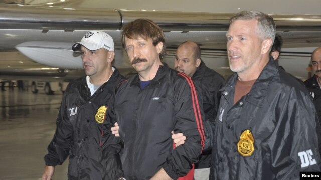 The Russian report says that the case of jailed Russian arms dealer Viktor Bout (center) shows U.S. "double standards" when it comes to human rights.