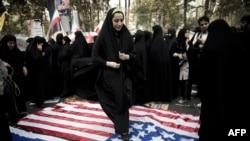 A woman steps on a U.S. flag outside the former U.S. embassy in Tehran.