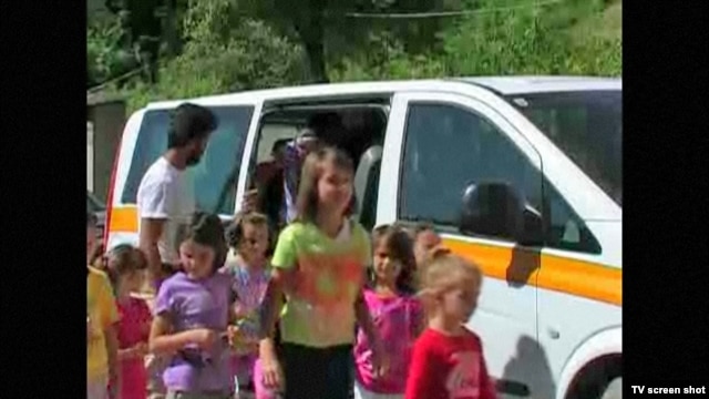 Schoolchildren from Liplje, Bosnia climb out of a minivan donated by a Dutch NGO to help them get to school. Screen shot from RFE/RL's "TV Liberty" program, 24Jul2012.