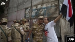 An Egyptian man welcomes an army soldier upon his deployment on a street leading to Cairo University on July 3.