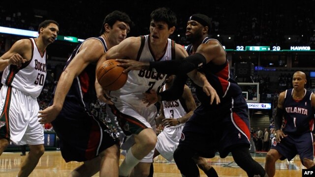 Zaza Pachulia (second from left) and Josh Smith of the Atlanta Hawks surround Ersan Ilyasova (center) of the Milwaukee Bucks as they battle for the ball during a 2010 NBA playoff game in Milwaukee.
