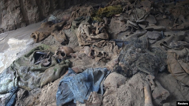 Human skeletons and items of clothing are seen in a mass grave uncovered in northern Balkh Province in January. Construction workers digging a car park found at least 10 human skulls.