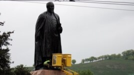 "Қарсылық жиыны" алдында Абай ескерткішін жуып жатқан жұмыскер. Алматы, 28 сәуір 2012 жыл.