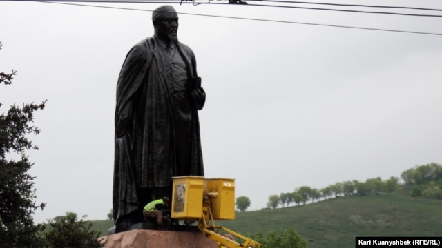 "Қарсылық жиыны" алдында Абай ескерткішін жуып жатқан жұмыскер. Алматы, 28 сәуір 2012 жыл.
