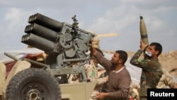Iraqi security forces and Shi'ite fighters reload a weapon during clashes with Islamic State as part of an offensive to reclaim the city of Tikrit from IS militants on March 2.