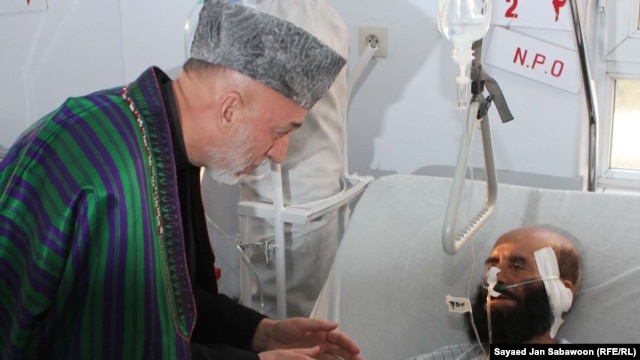 Afghan President Hamid Karzai visits victims of the blast in Kabul on December 7.