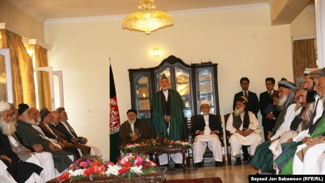 Afghan President Hamid Karzai (standing) speaks with members of the High Peace Council at its inauguration in Kabul, on October 7. One former Taliban leader describes the council as a good first step toward peace.