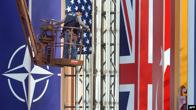 A worker installs flag on April 2 in preparation for the NATO summit in Strasbourg.