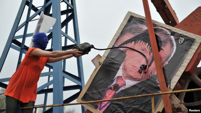Pussy Riot тобының мүшесі Ресейдің «Роснефть» мемлекеттік мұнай компаниясының басшысы Игорь Сечиннің портретіне мұнай шашып тұр.