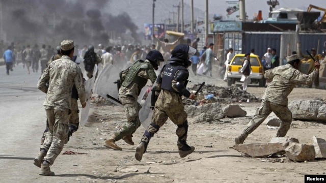 Afghan riot police run toward protesters during a demonstration in Kabul on September 17.