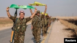 Kurdish fighters celebrate taking control of an area in Syria's Raqqa region last year.