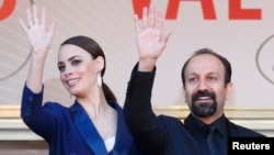 Asghar Farhadi (right), the director of "Le Passe," poses with star Berenice Bejo at the Cannes film festival in May.