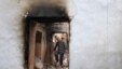 An ethnic Uzbek man walks through the ruins of his house, which was destroyed during ethnic clashes in Osh, on June 17.
