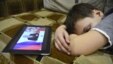 A boy in Vladivostok sleeps as his tablet computer shows Vladimir Putin's annual state-of-the-nation address on December 12.