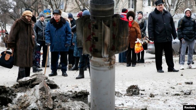 Жители Краматорска рассматривают снаряд, упавший в центре города