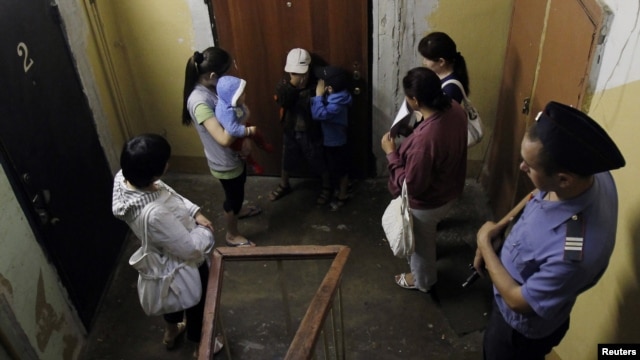 Kyrgyz women and their children are detained during a police raid on migrant workers in downtown Moscow last year.