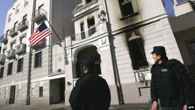 Serbian police look at a new flag raised at the U.S. Embassy in Belgrade in February 2008, which was set on fire by protesters enraged by Western support for Kosovo's independence.