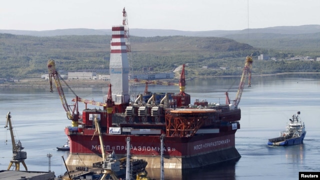 A floating oil platform is tugged from the harbor in the northern Russian port of Murmansk.