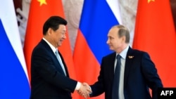 Russian President Vladimir Putin (right) shakes hands with his Chinese counterpart Xi Jinping during a ceremony to mark the signing of a number of bilateral traded deals in Moscow on May 8.