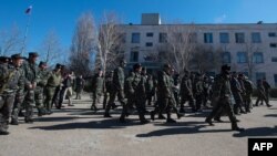Ukrainian soldiers walk out of a Ukrainian air force base in the small Crimean city of Novofedorivka after it was stormed by pro-Russian protesters on March 22.