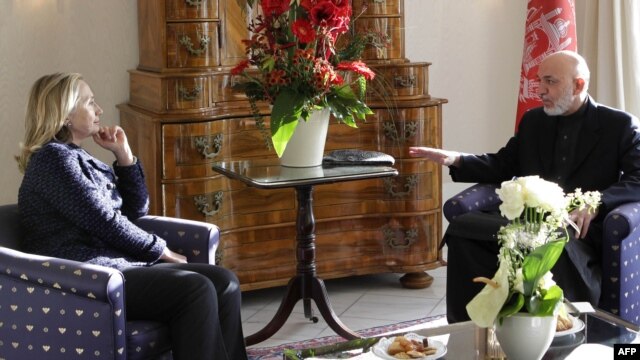 U.S. Secretary of State Hillary Clinton (left) and Afghan President Hamid Karzai speak during a bilateral meeting in Bonn.