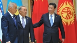 Қытай басшысы Си Цзиньпин (оң жақта), Қазақстан президенті Нұрсұлтан Назарбаев (ортада) және Өзбекстан президенті Ислам Кәрімов ШЫҰ саммитінде жүр. Бішкек, 2013 жылдың қыркүйегі.