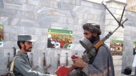 A former Taliban fighter (right) shakes hands with a policemen in Herat as he and other militants attend a ceremony to surrender under a U.S.-backed Afghan government amnesty scheme.
