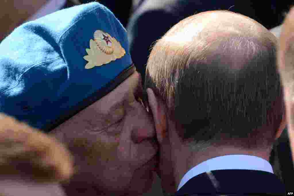 A World War II veteran kisses Russian President Vladimir Putin (right) after the Victory Day parade on Moscow's Red Square.