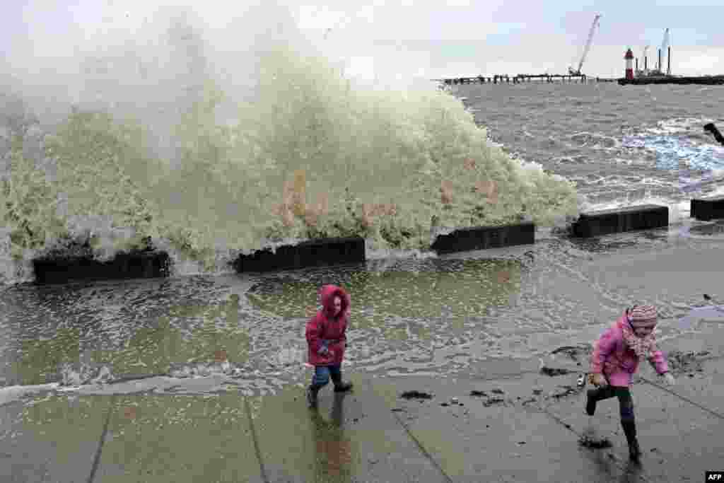 Girls run from a wave during a storm in the Russian Black Sea resort of Sochi on January 12. (AFP/Mikhail Mordasov)