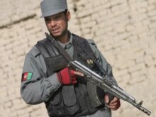 Afghanistan -- Afghan policeman stand alert at the site of a suicide attack on Afghan Parliametarian Padshah Khan Zadran representative of eastern Paktia province in Kabul, 22Dec2006