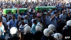 People shout slogans while they carry coffins of victims of a suicide bombing that killed at least 31 people in the town of Suruc near the border with Syria on July 20.