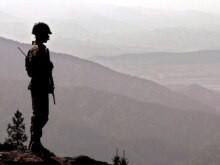 Pakistan -- A Pakistani army soldier stands alert monitoring the Afghan-Pakistani border at the Kundi Gar, 15Sep2005
