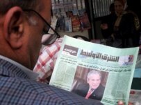 An Iraqi reads a newspaper about the release of the Iraq Study Group report, December 7 (epa)