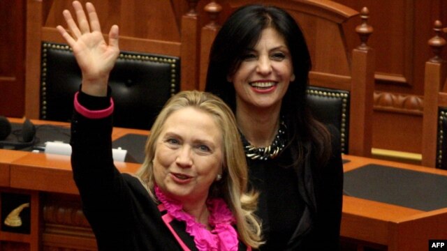 U.S. Secretary of State Hillary Clinton (left) waves after speaking to the Albanian parliament in Tirana, as speaker Josefina Topalli walks beside her.