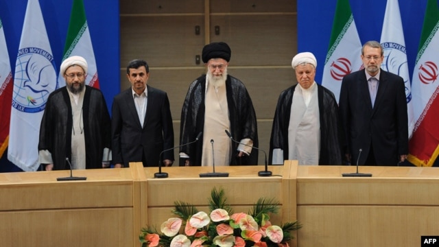 Former President Ali Akbar Hashemi Rafsanjani (second from right) stands next to Supreme Leader Ayatollah Ali Khamenei (center) at the opening session of the Nonaligned Movement summit in Tehran in August.
