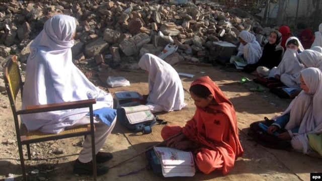 Girls sit amid the rubble of their destroyed school near the Afghan border, which was allegedly bombed by the Taliban militants in Bajaur in April.