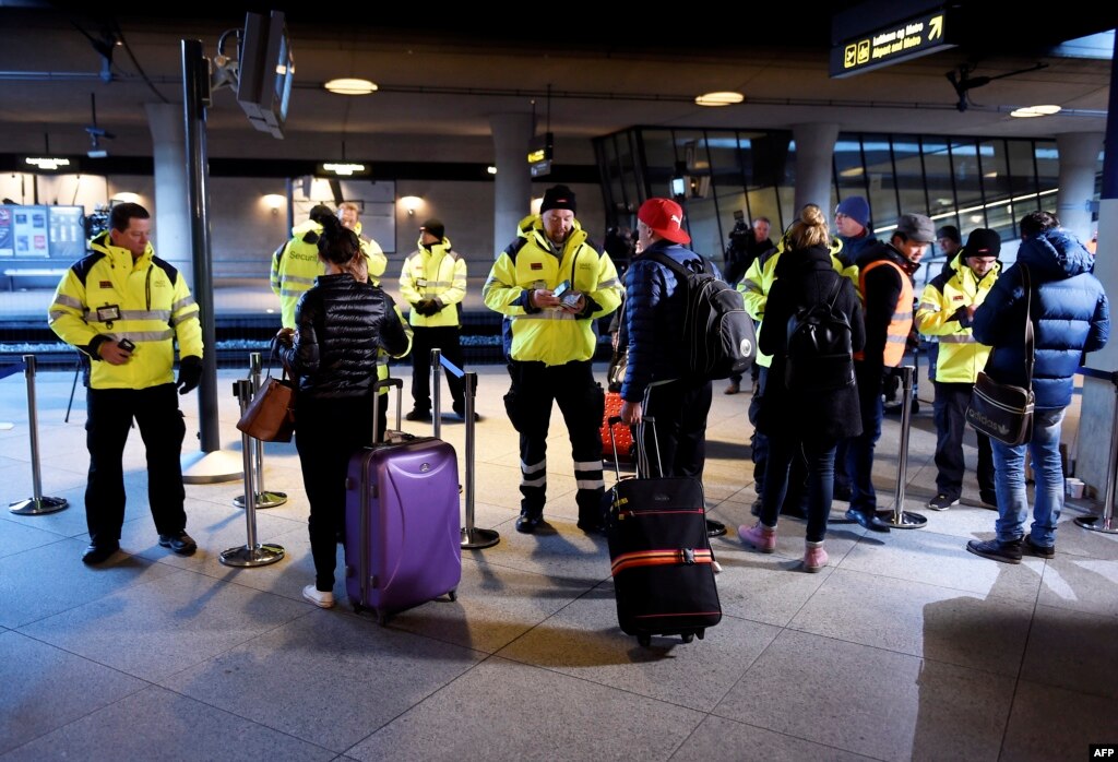 Сотрудники службы безопасности проверяют документы пассажиров на железнодородной станции Каструп под Копенгагеном
