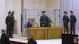 Surrounded by policemen, Dzmitser Kanavalaw (left) and Ulad Kavalyow are seen in a cage during their trial for the subway bomb in Minsk.