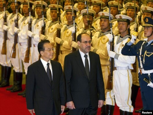 Iraqi Prime Minister Nuri al-Maliki (right), accompanied by Chinese Premier Wen Jiabao, reviews the military honor guard during a welcome ceremony at the Great Hall of the People in Beijing on July 18.