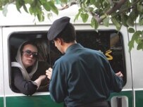 A woman in custody after being rounded up for a dress-code violation in Tehran in July (AFP)