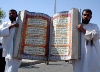Iraqis carry a huge replica of the Koran during a demonstration in Al-Basrah on September 18 (epa)