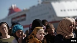 Greece--Refugee and migrant women line up as they wait to receive food distributed by Greek Red Cross at the port of Piraeus, near Athens, March 2, 2016.
