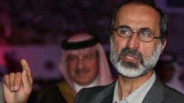 Ahmed Mouaz al-Khatib gestures after he was elected to lead the National Coalition of Forces of the the Syrian Revolution and Opposition on November 11.